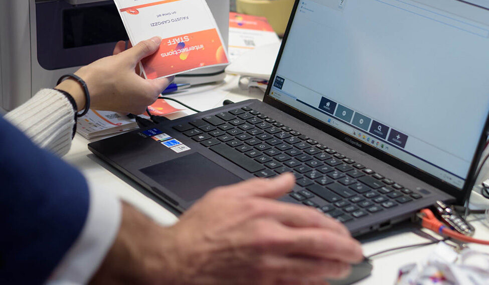 Particolare mano al portatile con stampa badge