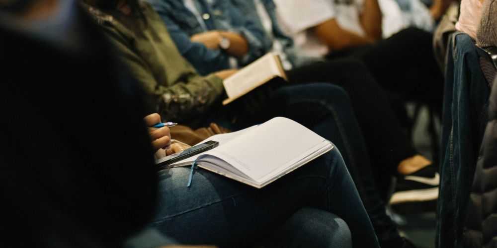 particolare persone sedute che prendon appunti